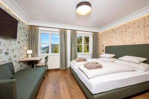a bedroom with a large bed and a desk at Kirchenwirt in Strobl