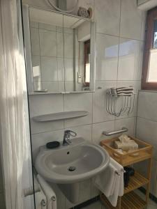 a white bathroom with a sink and a mirror at Ferienwohnung mit kleinem Garten in Nettersheim