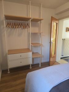 a bedroom with a bed and a closet with shelves at Ferienwohnung mit kleinem Garten in Nettersheim