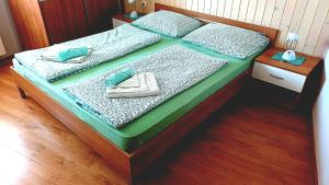a bed with two pillows and towels on it at Apartments Krn in Drežniške Ravne