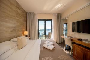 a hotel room with a bed and a desk and a television at Hotel Aleksandar Rafailovići in Budva