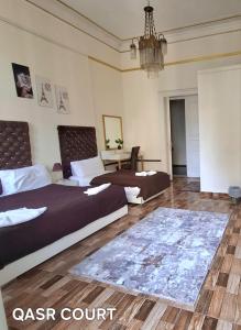 a hotel room with two beds and a table at Qasr court in Cairo