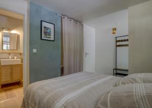 a bedroom with a bed and a sink and a mirror at Les totems de Grésigne in Penne