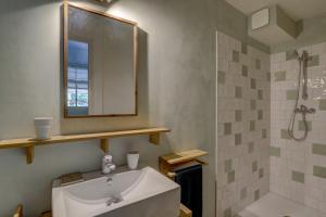 a bathroom with a sink and a mirror and a shower at Les totems de Grésigne in Penne +38 photos