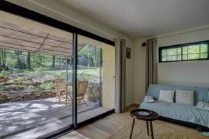 a living room with a couch and a patio at Les totems de Grésigne in Penne