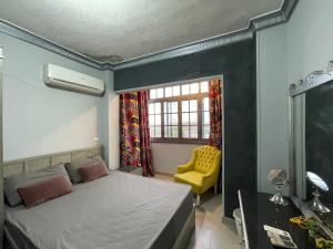 a bedroom with a bed and a yellow chair at Dora home in Cairo