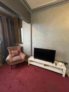 a living room with a tv and a chair at Dora home in Cairo