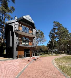 a building on a brick road in a park at Apartamenty Camping Morski in Łeba