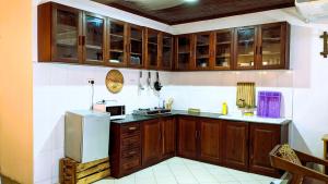 a kitchen with wooden cabinets and a refrigerator at Kays Place Train house Jambo in Zanzibar City +15 photos
