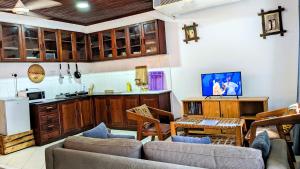 a living room with a couch and a kitchen at Kays Place Train house Jambo in Zanzibar City