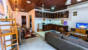 a living room with a couch and a kitchen at Kays Place Train house Jambo in Zanzibar City