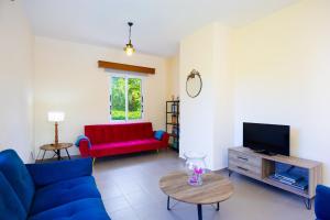 a living room with a blue couch and a tv at Sun Beach Villa Thio in Polis Chrysochous