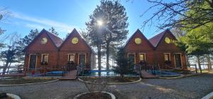 a wooden house with a playground in front of it at Dajti Alpin Villas in Tirana