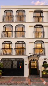 a tall white building with windows and doors at Hotel 86 Suites in Bogotá