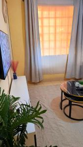 a living room with a table and a window at Luxe homes 1b in Kabuku
