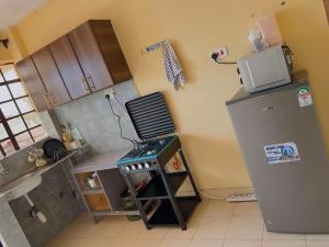 a small kitchen with a stove and a refrigerator at Luxe homes 1b in Kabuku