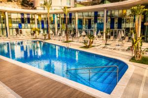 a large swimming pool in the middle of a building at Palladium Hotel Peñiscola in Peniscola +96 photos
