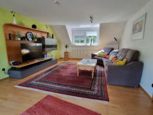 a living room with a couch and a tv at Zum Blauglockenbaum in Zell an der Mosel