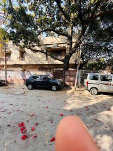 a car parked in a parking lot with red flowers at Giostay Residency in New Delhi