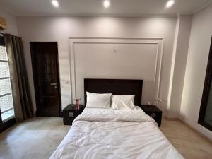 a bedroom with a large bed with white sheets and pillows at Giostay Residency in New Delhi +1 photo