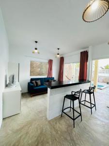 a living room with a counter and two stools at Chalés do Mirante in Coruripe