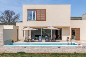 a house with a swimming pool in front of it at Villa Ventula in Šuljkove Kuće