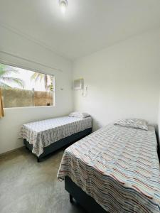 two beds in a room with a window at Chalés do Mirante in Coruripe +28 photos