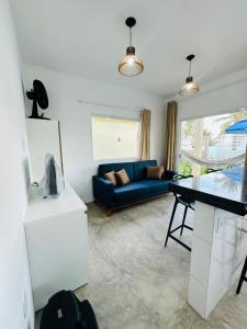 a living room with a blue couch and a table at Chalés do Mirante in Coruripe