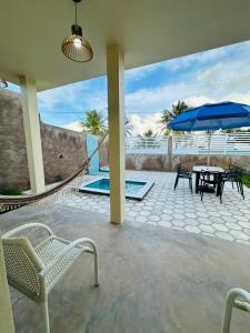 a patio with chairs and a table and an umbrella at Chalés do Mirante in Coruripe