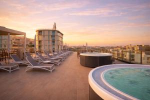 a balcony with chairs and a swimming pool on a building at Palladium Hotel Peñiscola in Peniscola