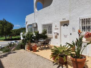 a patio with plants and a table in front of a building at Lorarno in Praia do Carvoeiro