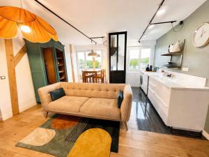 a living room with a couch and a kitchen at Les Rives Rémoises in Reims