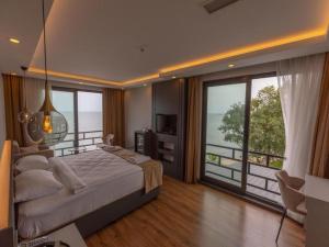 a bedroom with a large bed and a balcony at Santana Resort Otel in Trabzon
