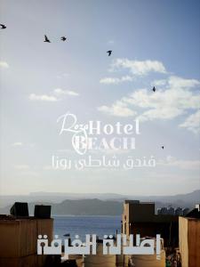 a sign for a beach with birds flying in the sky at Aqaba Roza in Aqaba