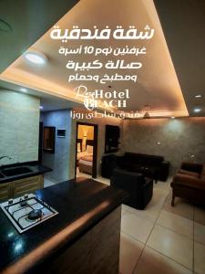 a kitchen with a stove and a living room at Aqaba Roza in Aqaba
