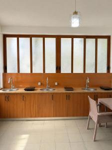 a bathroom with three sinks and a table and windows at Aurea Rooms in Vlorë