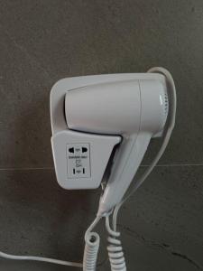 a white hairdryer with a cord plugged into it at Aurea Rooms in Vlorë