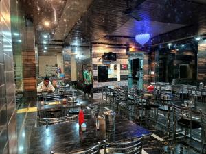 a dining room with tables and chairs in a restaurant at RK Residency Hotel & Resturant in Ukhimath