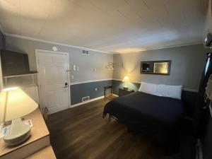 a small bedroom with a bed and a door at Martin's Motel USA in Madawaska +4 photos
