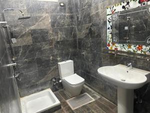 a bathroom with a white toilet and a sink at Kimka in Aswan