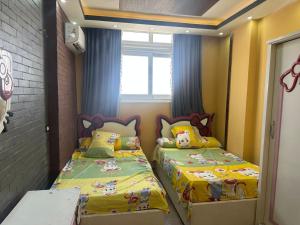a small bedroom with two beds and a window at Kimka in Aswan