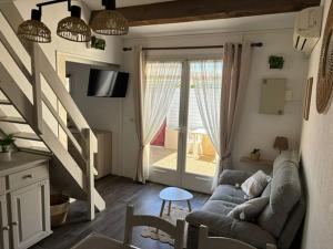 a living room with a couch and a staircase at Maisonnette cosy à 400 m de la plage - Saint Cyprien in Saint-Cyprien-Plage