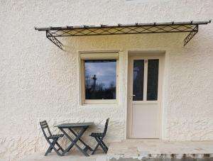 a table and two chairs in front of a door at Chambres d'hôtes in Annoisin-Chatelans