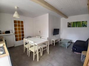 a dining room with a white table and chairs at Chambres d'hôtes in Annoisin-Chatelans