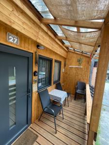 a wooden deck with a table and chairs on it at Chatky U Davida Máchovo jezero in Staré Splavy