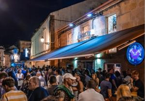 a crowd of people walking down a street at night at Orballo in Vilagarcia de Arousa