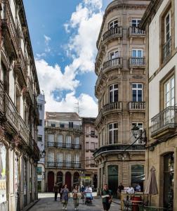 a group of people walking down a street in front of buildings at Orballo in Vilagarcia de Arousa