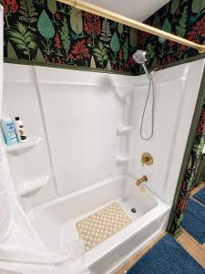 a bathroom with a shower and a tub at Peach Door Cottage in Lufkin +20 photos