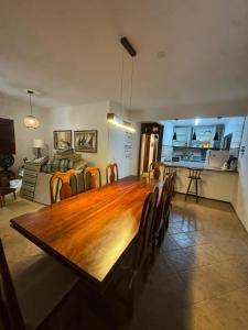 a dining room with a large wooden table and chairs at Casa Flamboyant Parajuru in Beberibe