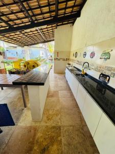 a kitchen with a sink and a counter top at Casa Flamboyant Parajuru in Beberibe